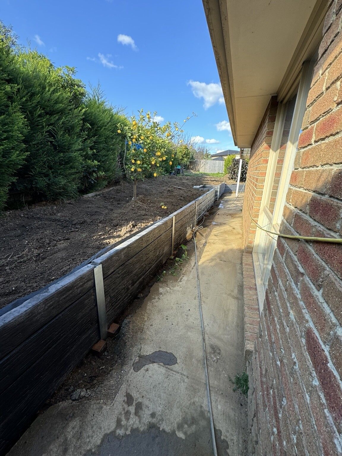Berwick project: Concrete sleeper retaining wall with concrete sleepers, galvanised steel posts, integrated sleeper staircase. Photo 3 of 4.