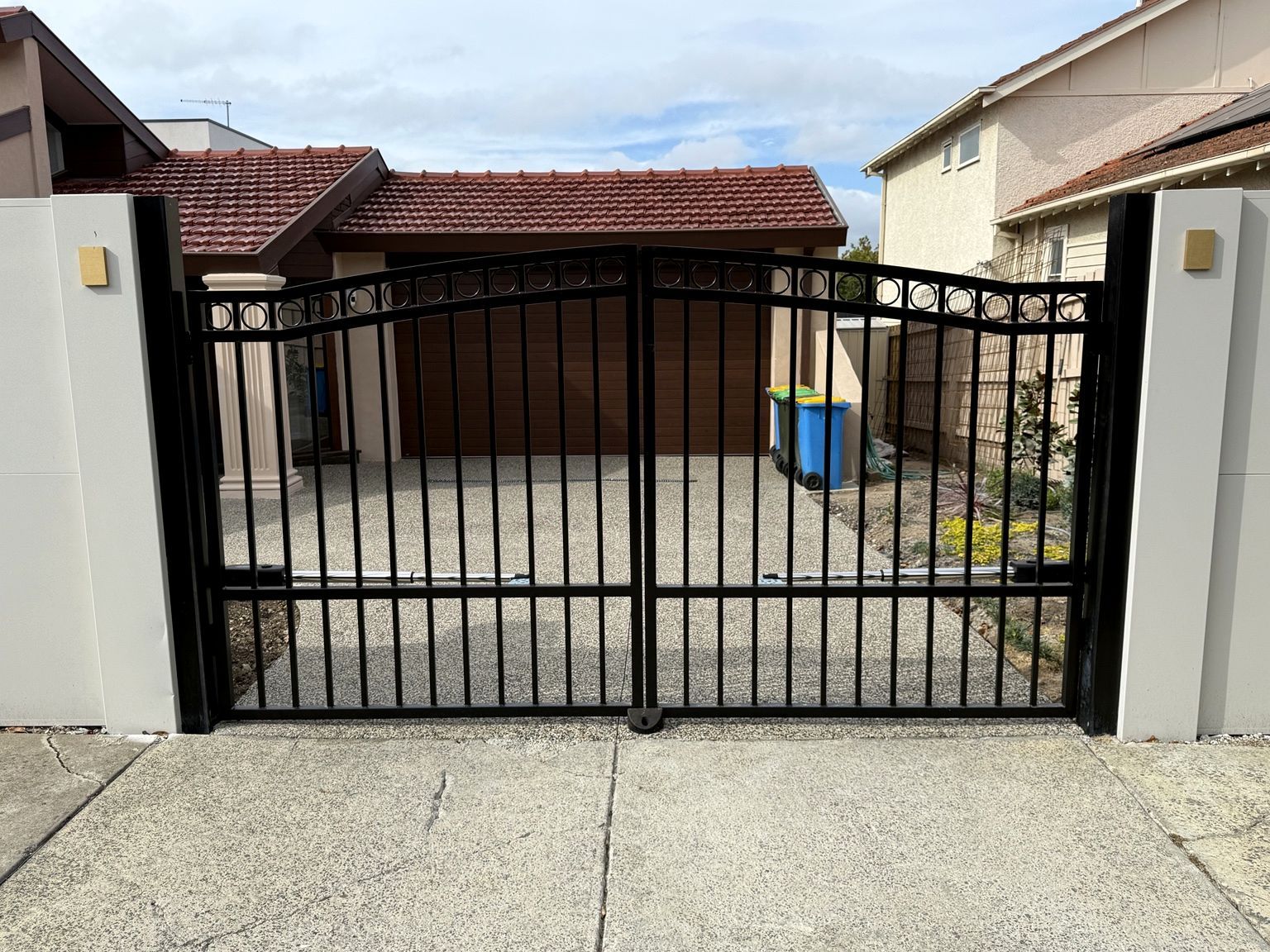Black automated swing driveway gates, closed, between two EstateWall piers, Camberwell.