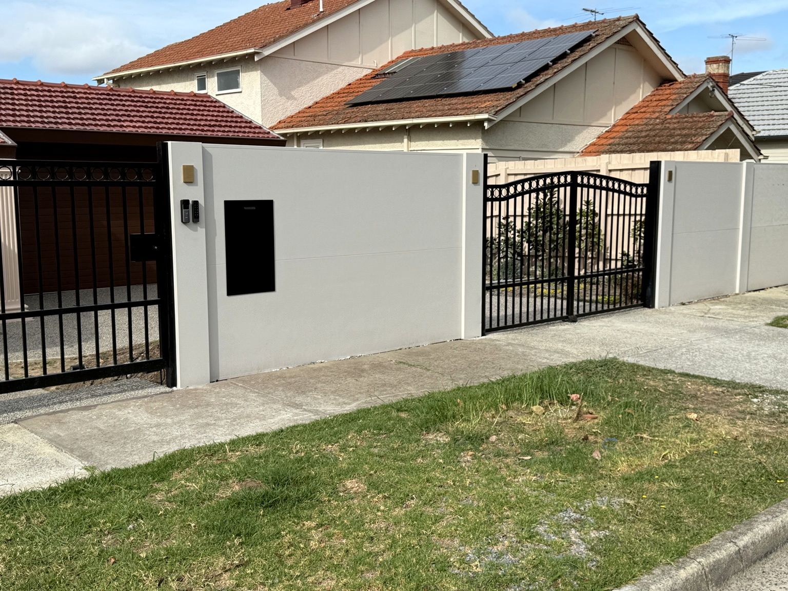 Camberwell: EstateWall with black swing driveway gates, a matching pedestrian gate, an intercom and keypad on the post and a parcel box set into the wall.