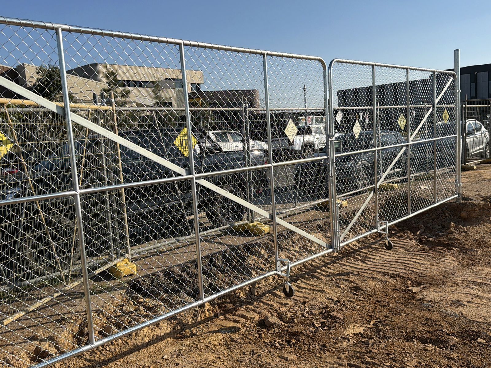 Clyde North site gates project: Custom site entry gates with pair of site-entry swing gates, posts and locking hardware. Photo 2 of 2.