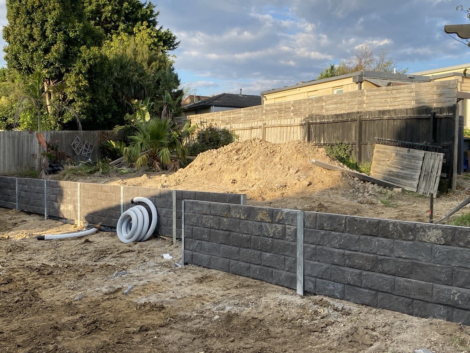 Frankston South project: Concrete sleeper retaining walls with concrete sleepers, galvanised steel posts, drainage, with a plumber. Photo 1 of 4.