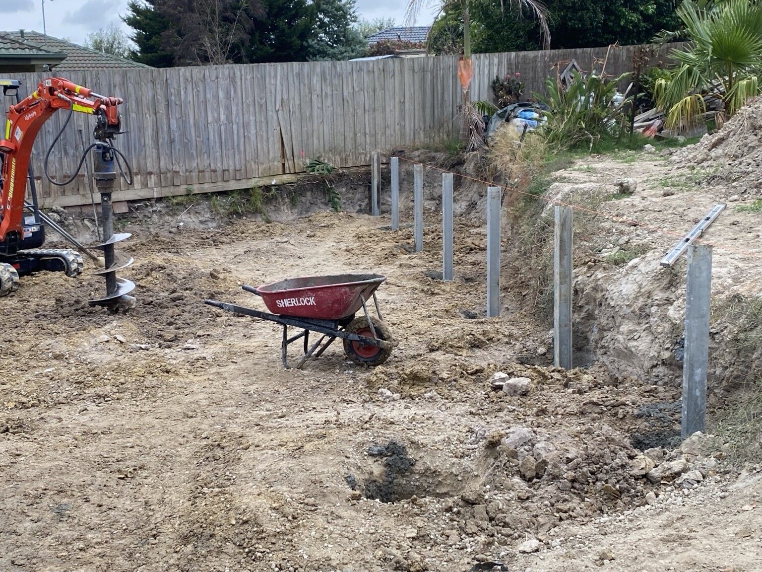 Frankston South project: Concrete sleeper retaining walls with concrete sleepers, galvanised steel posts, drainage, with a plumber. Photo 2 of 4.