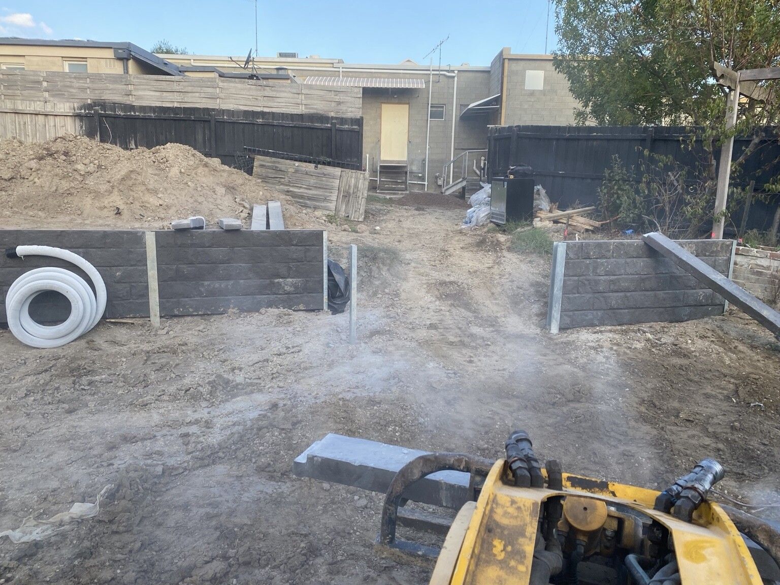 Frankston South project: Concrete sleeper retaining walls with concrete sleepers, galvanised steel posts, drainage, with a plumber. Photo 3 of 4.
