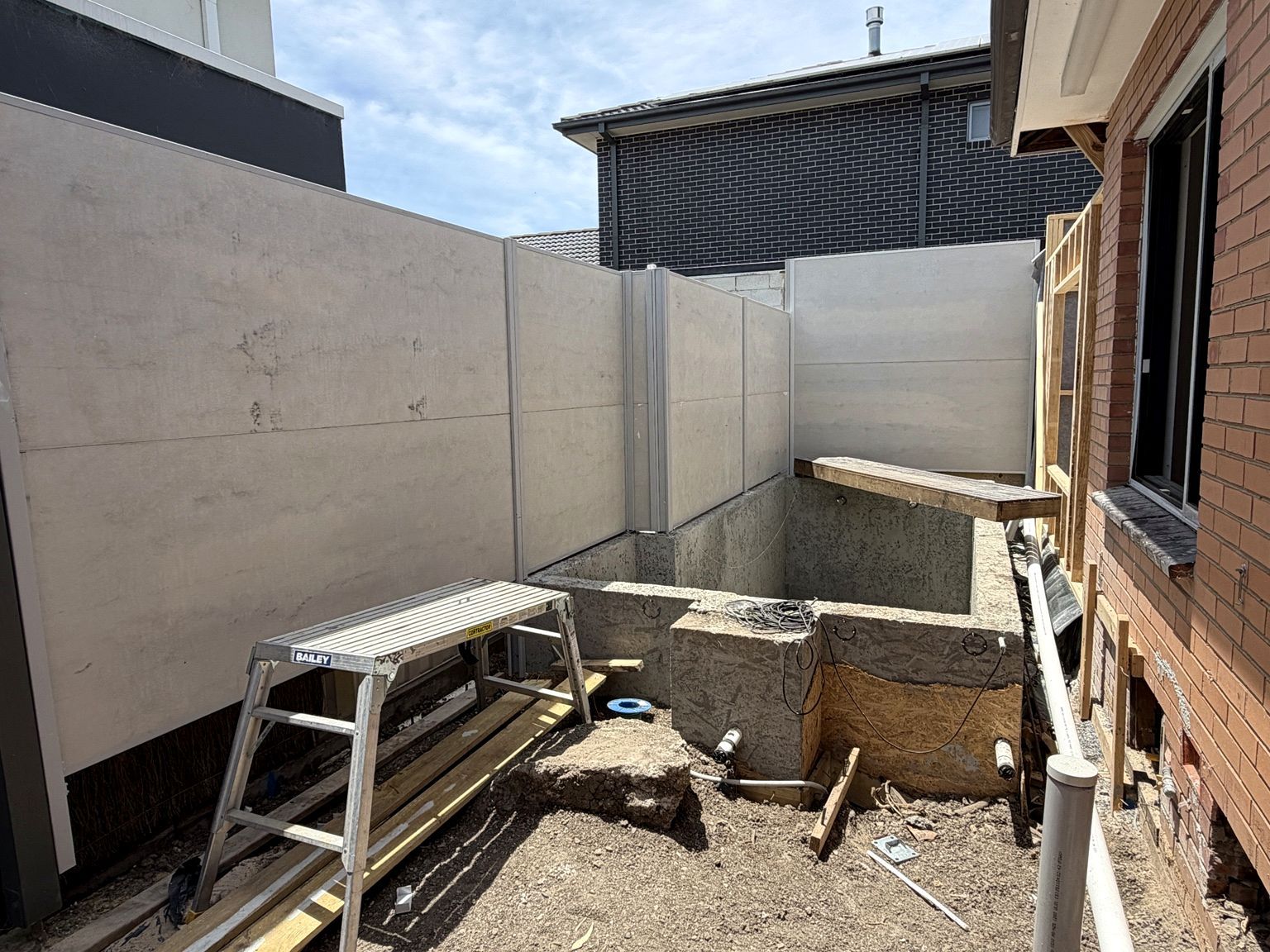 Newport project: SlimWall Classic with pool boundary, alfresco area, before-and-after sequence. Photo 2 of 4.
